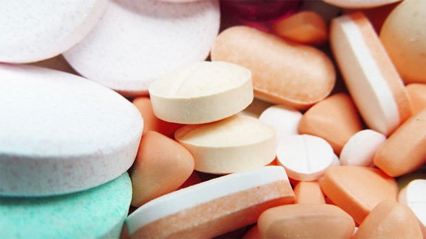 На столе груда разнообразных лекарств в таблетках